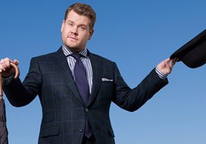 James Corden standing with umbrella